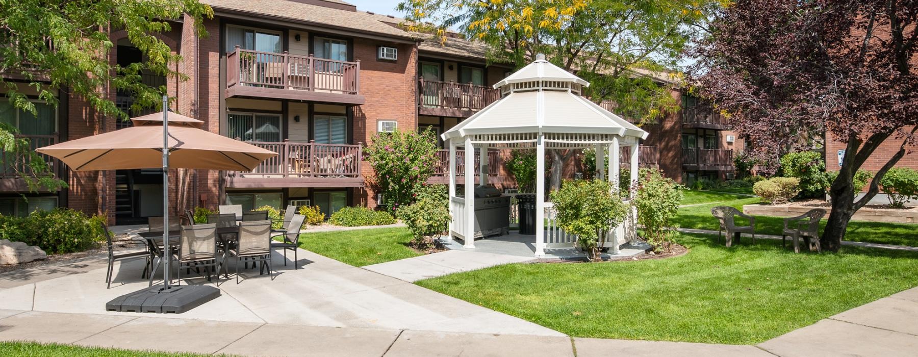 a building with a patio and tables and chairs in front of it